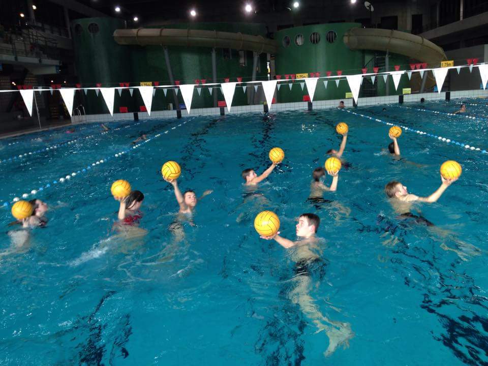 Competitiezwemmers met een waterpolobal